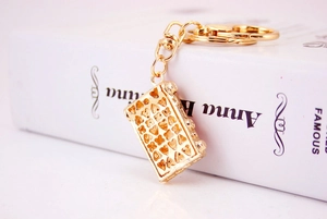 Detail view of gold keychain pendant featuring a hollow heart pattern and lobster clasp