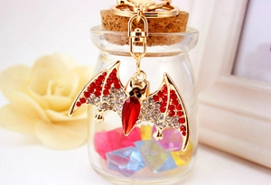 Detail of bat keychain with red crystals hanging on a decorative glass bottle