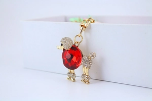 Dettaglio del portachiavi a barboncino dorato con strass brillanti e grande cristallo rosso