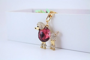 Dettaglio portachiavi a forma di barboncino con cristallo rosso rosa e strass bianchi