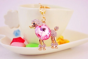 Dettaglio portachiavi a forma di barboncino dorato con grande cristallo rosa e strass