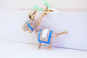 Détail macro d'un porte-clés âne scintillant avec émail bleu et finition dorée