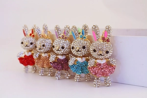 Dettaglio di cinque portachiavi a forma di coniglio con strass colorati ed eleganti
