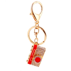 Sparkling crystal camera keychain with red lens detail and golden finish for handbags