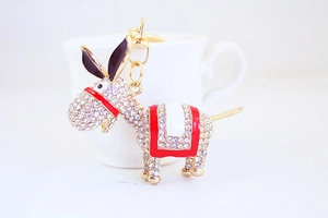 Close-up of rhinestone donkey keychain with gold plating and red enamel details