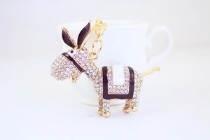 Detailed macro view of rhinestone donkey keychain with gold plating and enamel details