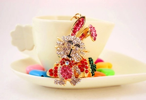 Détail d'un porte-clés lapin mignon avec strass colorés suspendu sur une tasse en céramique