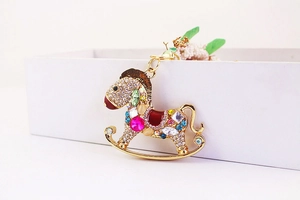 Détails des strass colorés sur un porte-clés cheval à bascule plaqué or brillant