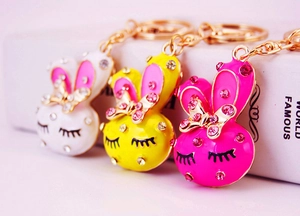 Detailed close-up of cute cartoon bunny keychains with colorful enamel and sparkling crystals
