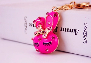 Close-up of cute pink bunny keychain with glittering rhinestones and golden accents