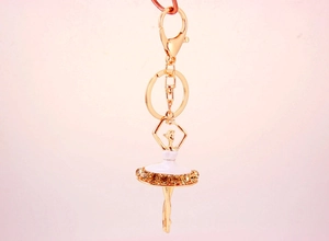 Dettaglio portachiavi ballerina con gonna in smalto bianco e strass ambrati scintillanti