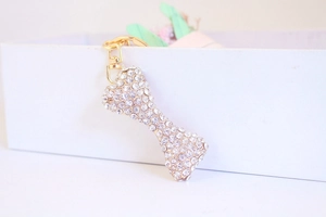 Close-up of sparkling rhinestone bone keychain with gold metal plating and ring hook