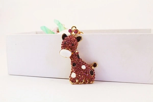 Vue détaillée du pendentif girafe en strass rose avec métal doré poli et jolis détails