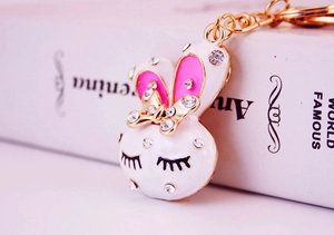 Detail of cute rabbit keychain with white enamel, pink accents, and sparkling rhinestones