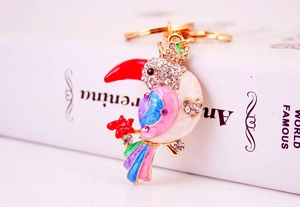 Close-up of vibrant enamel kingfisher keychain with sparkling crystals and golden crown