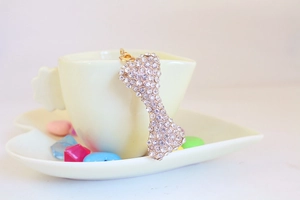 Detailed view of rhinestone bone keychain featuring sparkling crystals and gold lobster clasp