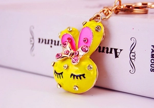 Close-up of cute yellow bunny keychain with pink rhinestone bow and gold lobster clasp