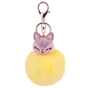 Detail of fox head keychain with sparkling rhinestones and a fluffy yellow faux fur ball