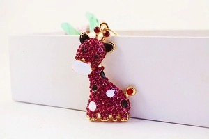 Détail du porte-clés girafe avec strass violets et finitions métalliques dorées