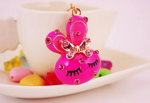 Close-up of pink rhinestone cartoon rabbit keychain with gold bow and heart accents