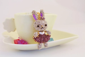 Dettaglio del portachiavi a forma di coniglio con strass viola vicino a una tazza