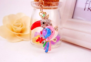 Detailed view of luxury rhinestone kingfisher keychain with colorful enamel body and gold finish