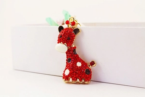 Vue macro du pendentif girafe doré avec strass rouges et détails en émail fin