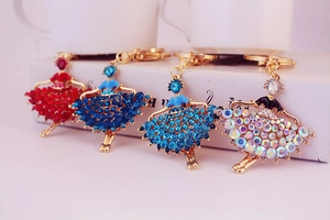 Close-up of ballet girl keychains in four colors with crystal rhinestones and gold plating