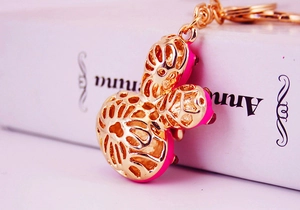 Close-up of golden Mickey-shaped hollow metal keychain with rose red lining