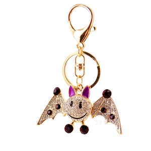 Golden bat keychain with sparkling white and red rhinestones and purple enamel details