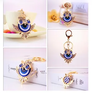 Détail macro du porte-clés hibou avec motif oeil bleu et strass brillants