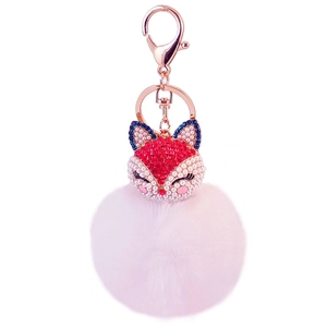 Detailed close-up of pink fluffy pom-pom keychain with crystal fox head and rose gold clasp