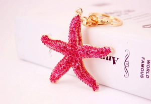 Macro detail of a sparkling rose red rhinestone starfish keychain with gold plating