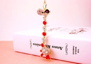 Detail of giraffe keychain with gold alloy, sparkling rhinestones and red enamel dots