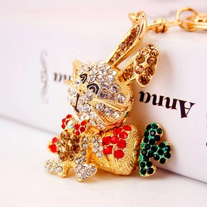 Charmant porte-clés lapin doré avec strass scintillants tenant une petite carotte