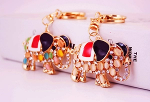 Close-up of golden elephant keychains with opal inlay and sparkling white rhinestones