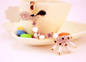 Detail shot of a golden giraffe keychain with white crystals and black enamel spots