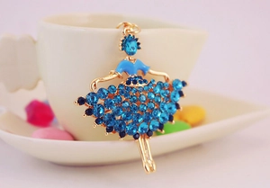 Detailed macro view of gold-plated ballet dancer charm with blue rhinestones and enamel