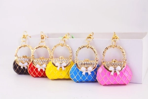 Five assorted colors of rhinestone handbag keychains with bow details and quilted finish