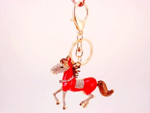 Detail view of red enamel horse keychain with sparkling rhinestones and gold ring