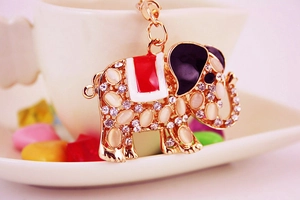 Macro view of elephant keychain with opal stones and crystals on white ceramic