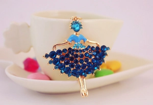 Detailed view of a golden ballet girl keychain with blue rhinestones on a white cup