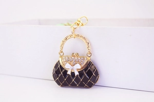 Detailed macro view of quilted enamel handbag keychain with bow and rhinestones