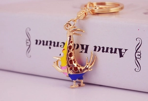 Close-up of golden cartoon rooster keychain with colorful enamel coating and metal clasp