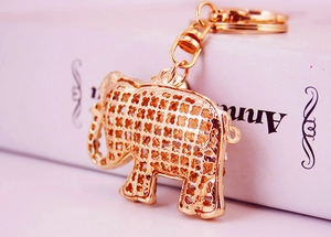 Detail of golden elephant keychain featuring hollow clover mesh and rotating metal clasp