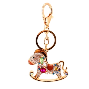 Porte-clés cheval à bascule étincelant avec strass colorés sur une base dorée