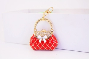 Detailed macro view of a red quilted handbag keychain with white rhinestones and gold hook
