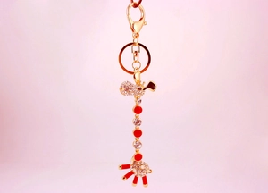 Close-up of golden giraffe keychain with sparkling rhinestones and red enamel dots