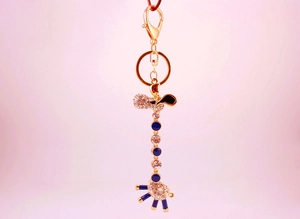Detailed view of giraffe keychain with white crystals and navy blue enamel accents