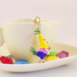 Porte-clés coq en émail coloré avec cristaux suspendu à une tasse en porcelaine blanche